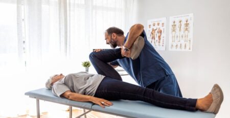Male Doctor Chiropractor Fixing Womans Leg with Hands Movements