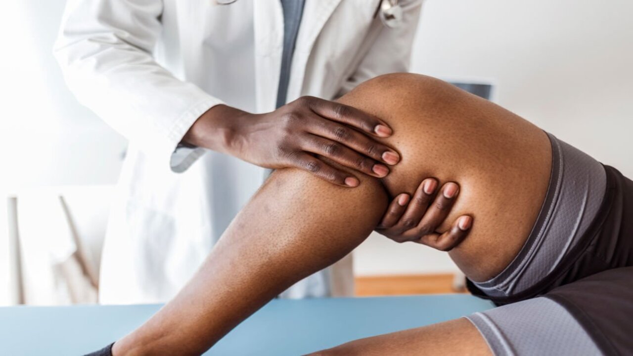 Doctor Examining a Knee of a Woman During an Appointment.